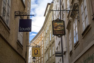 Salzburg, Avusturya - 25 Temmuz 2017. Getreidegasse, Salzburg 'un ünlü alışveriş caddesi Eski Şehir, Mozarts Doğum Yeri, dünyanın dört bir yanından gelen ziyaretçiler için gidilecek yer. St. Blaises Kilisesi.