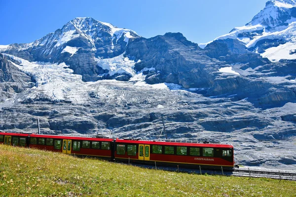 Jungfraujoch 'tan (Avrupa' nın tepesi) Kleine Scheidegg, Bernese Oberland, İsviçre 'ye kadar meşhur Jungfrau Demiryolu' nun çarkıfelek kırmızı treniyle güzel bir manzara.