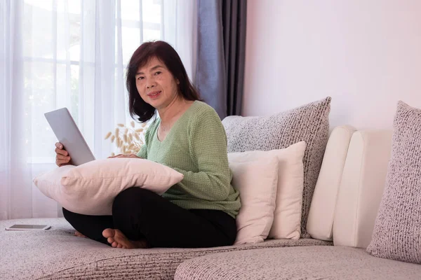 Mooi meisje thuis met behulp van laptop op de Bank, ouderen Aziatische — Stockfoto