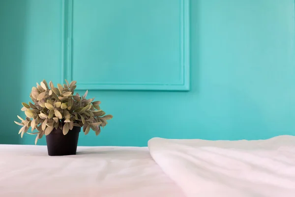 Plant pot on white bed in bedroom at home. — Stock Photo, Image