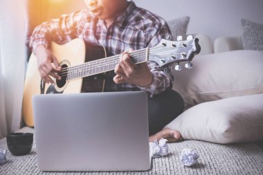 yatakta gitar çalan şarkıcı.