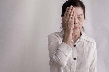 izole arka plan üzerinde göz ağrısı olan asyalı yaşlı kadın.
