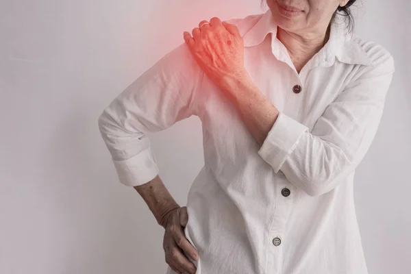 Asiático anciana teniendo hombro dolor en aislado blanco espalda —  Fotos de Stock