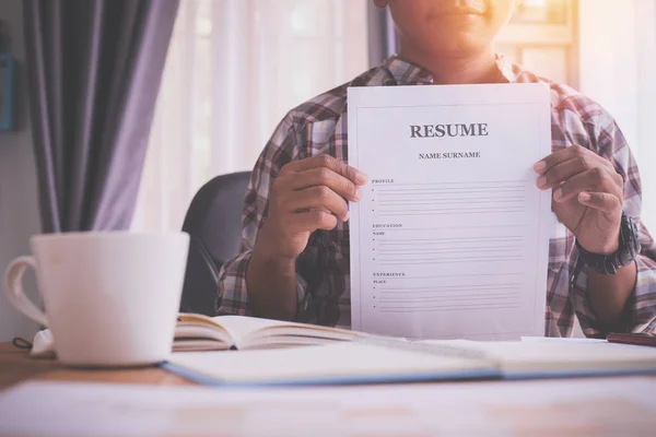 Office table with businessman showing resume form. — Stock Photo, Image