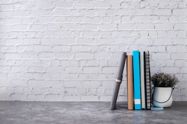 evde tuğla duvar üzerinde kitap ve defter kağıt.