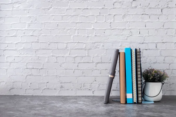 evde tuğla duvar üzerinde kitap ve defter kağıt.