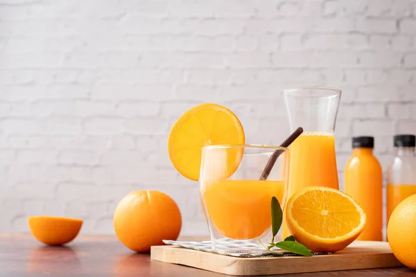 Tavolo in legno con bicchieri di succo d'arancia appena spremuto, senza aggiungere — Foto Stock