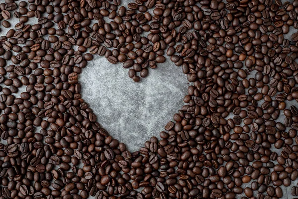 Coffee beans with heart shape sign on dark wall texture backgrou — Stock Photo, Image