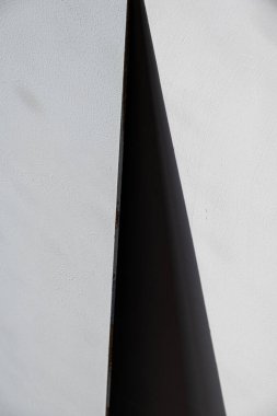 Beton bir duvarda üçgen şeklinde siyah bir gölge. Özgeçmiş, soyutlama. Gri.