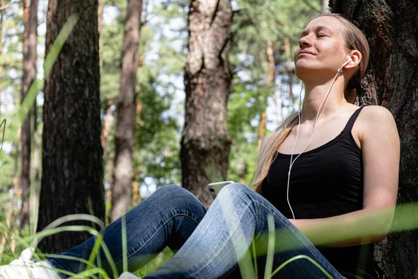 Uma Menina Uma Floresta Senta Encostada Uma Árvore Com Fones — Fotografia de Stock