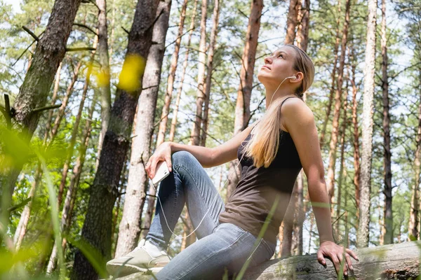 Uma Menina Uma Floresta Senta Uma Árvore Com Fones Ouvido — Fotografia de Stock