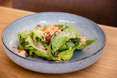 Karidesli sezar salatası, çam fıstığı, parmesan peyniri bir restorandaki masada. Sağlıklı yemek. organik gıda. Detoks