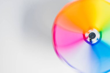 Beyaz arka planda çok renkli rüzgâr oyuncakları var. Bıçaklar gökkuşağı şeklinde bulanık bir iz bırakıyor. LGBTQ + işareti, amblem. Metin için boşluk