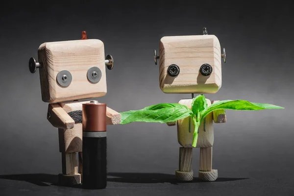 Bataryası ve yaprakları olan ahşap robot, atık geri dönüşümü konsepti, çevresel koruma, pil geri dönüşümü. Doğa teknolojiye karşı