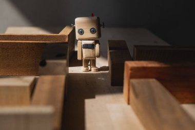 Tahta bloklardan oluşan labirentte küçük tahta bir robot. yol seçim konsepti