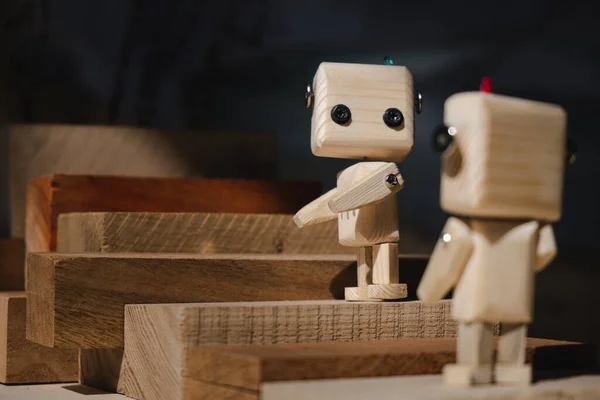 İki küçük tahta robot tahta bloklardan bir merdivene tırmanıyor. takım çalışması konsepti
