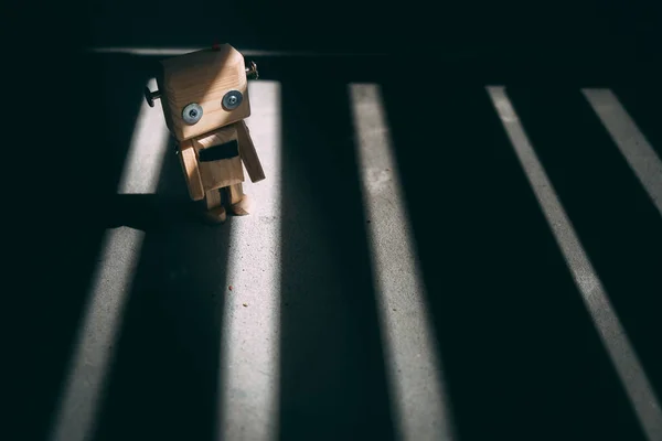 Tahta oyuncak robot, pencereden yansıyan ışık, gölge ve ışık çizgileri oluşturur. Hayattaki siyah beyaz şerit