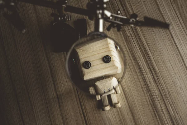 Ahşap robot android bir büyüteç altında masanın üzerinde yatıyor. Büyüteçle bir bilim adamının üçüncü eli. Yapay zeka geliştirme