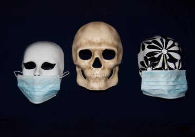 Virüsün yayılma koşullarında koruyucu bir tıbbi maske takan bir insan kafatasının maskesi.
