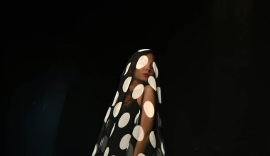 Siyahlı güzel kız siyah pareo ile dans ediyor.