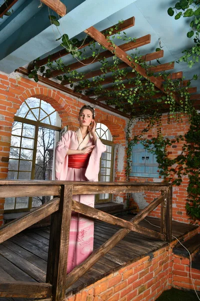 girl in pink japanese kimono on a background of flowers