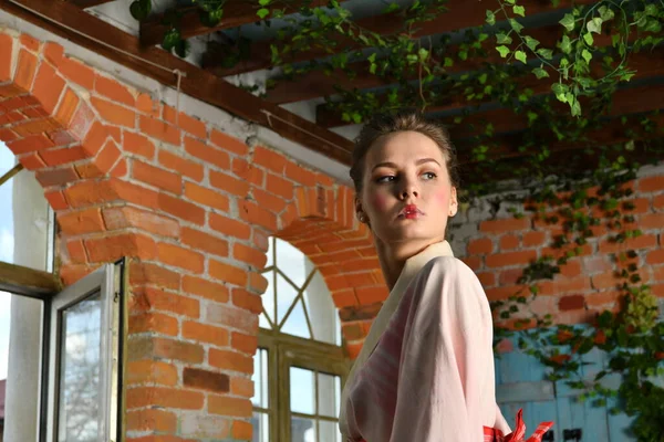 ピンクの着物を着た女の子が花を背景に — ストック写真