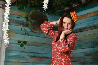 Kırmızı elbiseli güzel kız odanın içinde poz veriyor.