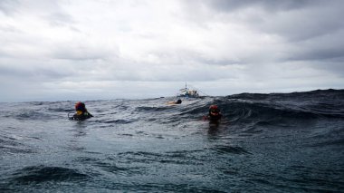 Yükselen dalgıç teknenin gelmesini bekliyor.