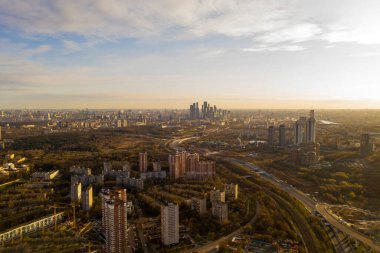 Şehir panoramik manzarası, gün batımında evler ve yollar bir kuadrokopterden çekiliyor.