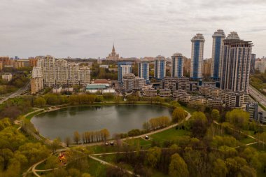 city panoramic view with houses and roads and with a lake taken from a quadrocopter clipart
