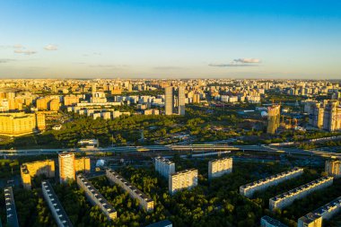 Şehir panoramik manzarası, gün batımında evler ve yollar bir kuadrokopterden çekiliyor.