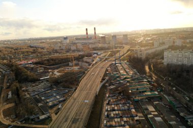 Şehir panoramik manzarası, gün batımında evler ve yollar bir kuadrokopterden çekiliyor.