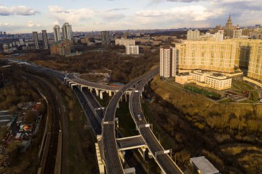 Şehir panoramik manzarası, gün batımında evler ve yollar bir kuadrokopterden çekiliyor.