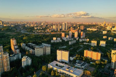 Şehir panoramik manzarası, gün batımında evler ve yollar bir kuadrokopterden çekiliyor.