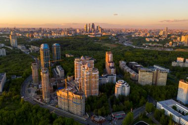 Şehir panoramik manzarası, gün batımında evler ve yollar bir kuadrokopterden çekiliyor.