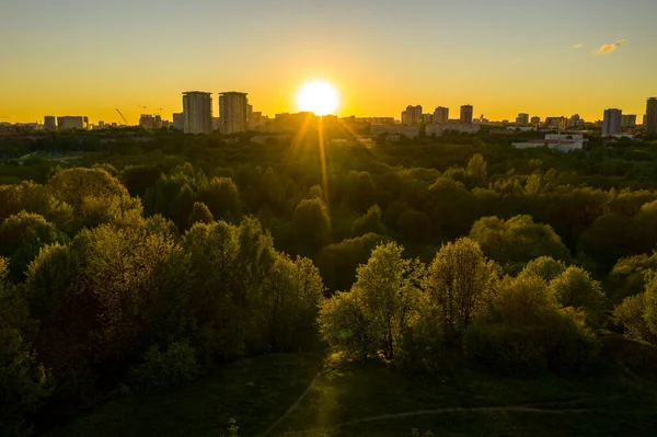 Şehir panoramik manzarası, gün batımında evler ve yollar bir kuadrokopterden çekiliyor.