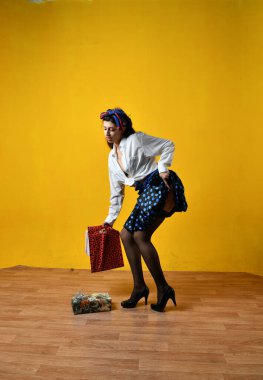 Beyaz bluzlu güzel bir kız. Sarı arka planda poster tarzı poz veriyor.