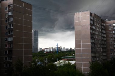 thunderclouds cling to tall apartment buildings clipart