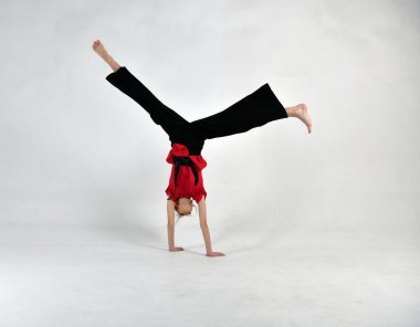 Siyah ve kırmızılı güzel kız dövüş sanatlarında ustalaşmak için egzersiz yapıyor.