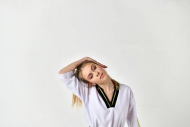 Siyah beyaz kimonolu güzel kız dövüş sanatları stili egzersizleri yapıyor.