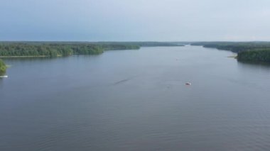 Motorlu tekneler nehir boyunca bir insansız hava aracından çekilen güzel bir manzaranın arka planına karşı gider.