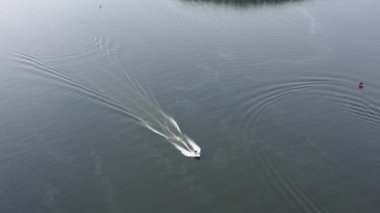 Motorlu tekneler nehir boyunca bir insansız hava aracından çekilen güzel bir manzaranın arka planına karşı gider.