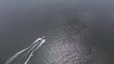 Motorlu tekneler nehir boyunca bir insansız hava aracından çekilen güzel bir manzaranın arka planına karşı gider.