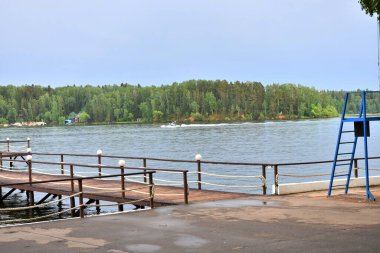 Nehir ve orman üzerinde iskelesi olan bir manzara.