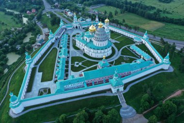 İHA 'dan çekilen yüksek yeşil bir tepenin üzerindeki antik bir kale-manastırın panoramik görüntüsü