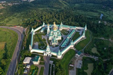 İHA 'dan çekilen yüksek yeşil bir tepenin üzerindeki antik bir kale-manastırın panoramik görüntüsü