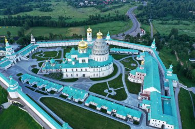 İHA 'dan çekilen yüksek yeşil bir tepenin üzerindeki antik bir kale-manastırın panoramik görüntüsü