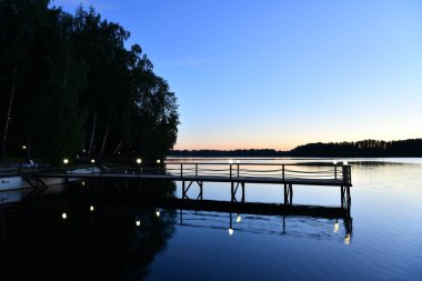 Gün doğumunda nehirde pembe bulutların yansıması