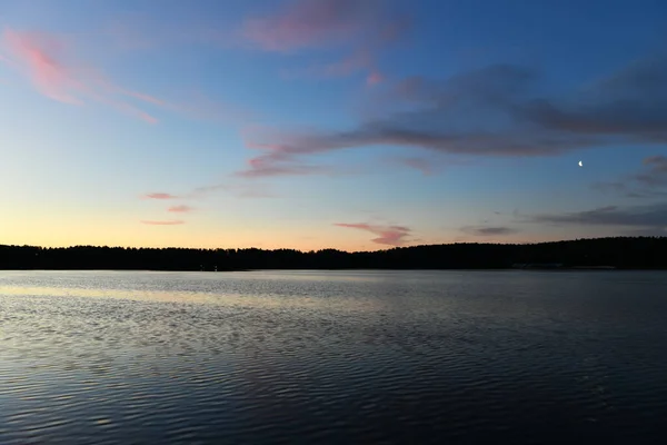 reflection of pink clouds in a river at sunrise