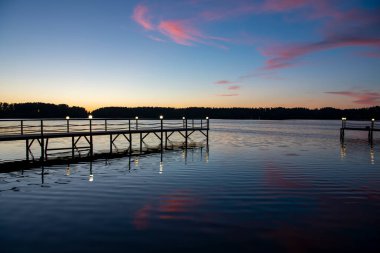 Gün doğumunda nehirde pembe bulutların yansıması